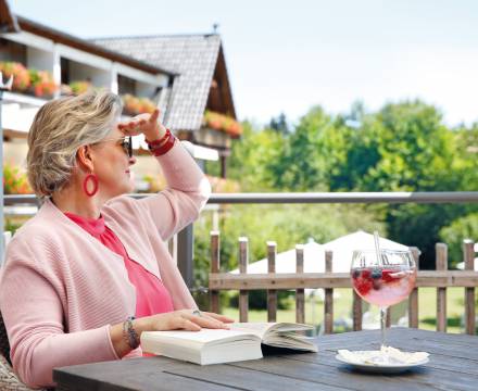 Gast auf Sommerwiese vor Hotel Grüner Wald Freudenstadt